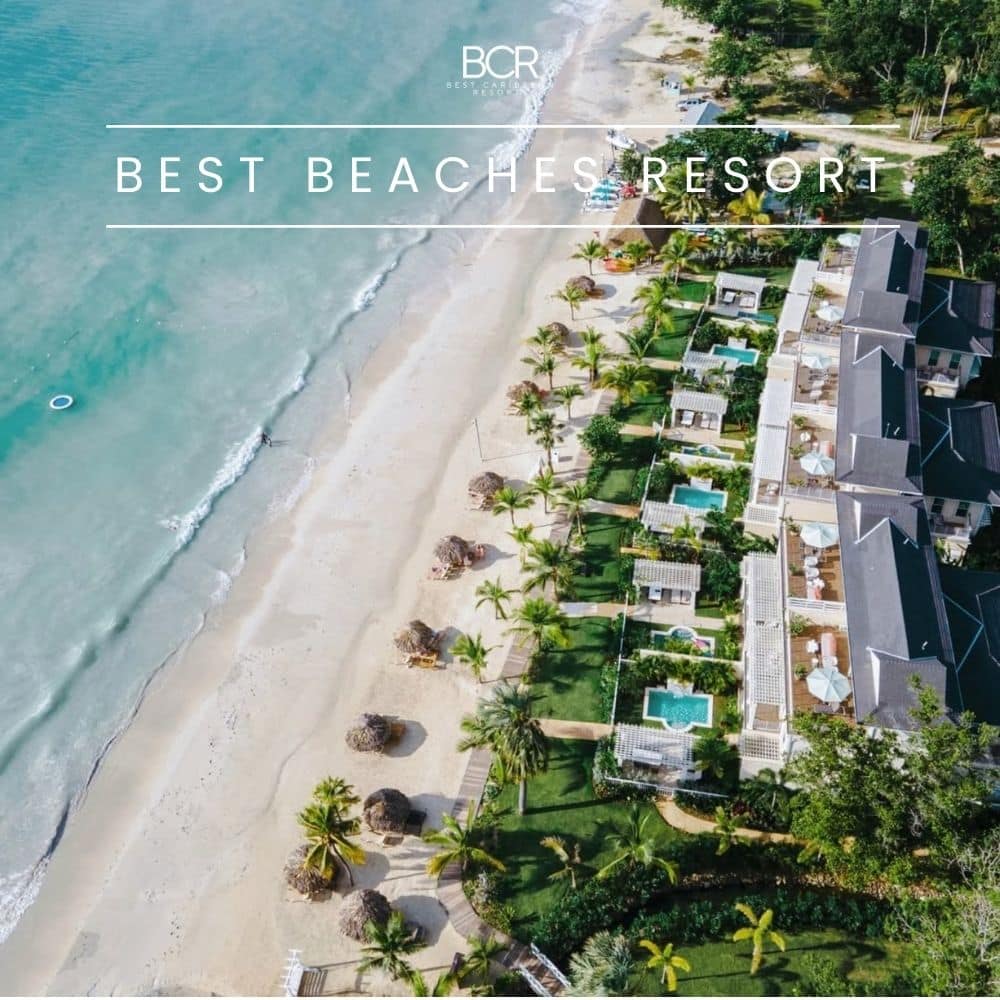 Aerial view of the Best Beaches resort in Negril resort with a sandy shoreline, palm trees, and beach cabanas, featuring several swimming pools and lounge areas adjacent to the ocean.